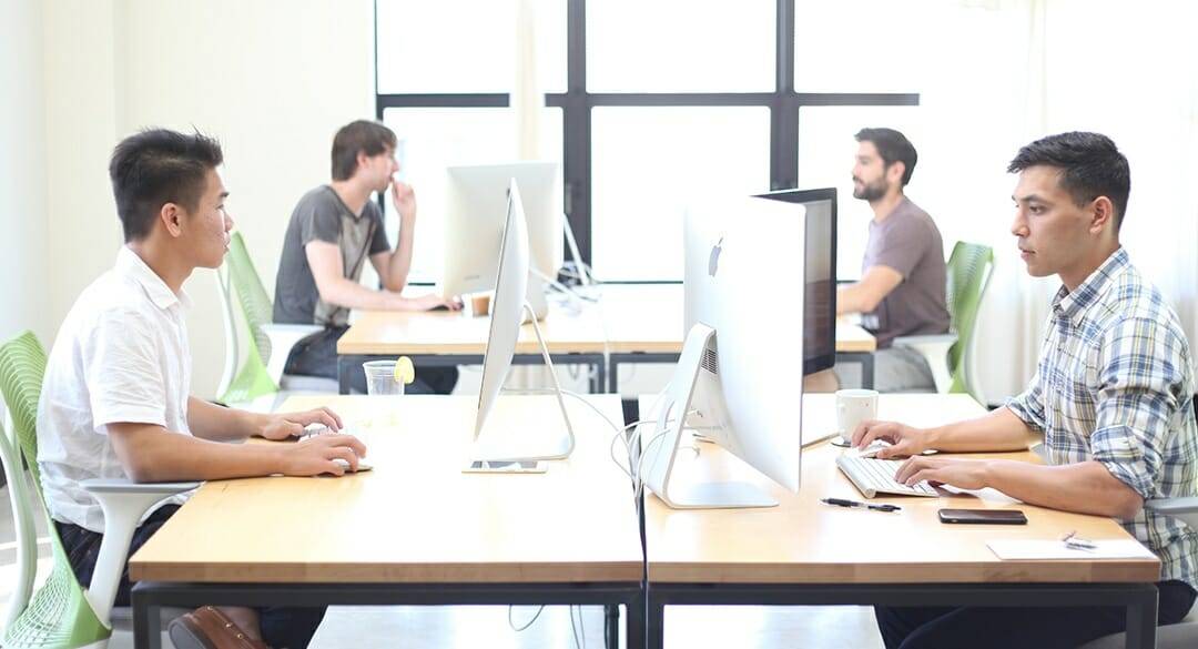Young men sitting at computer work stations